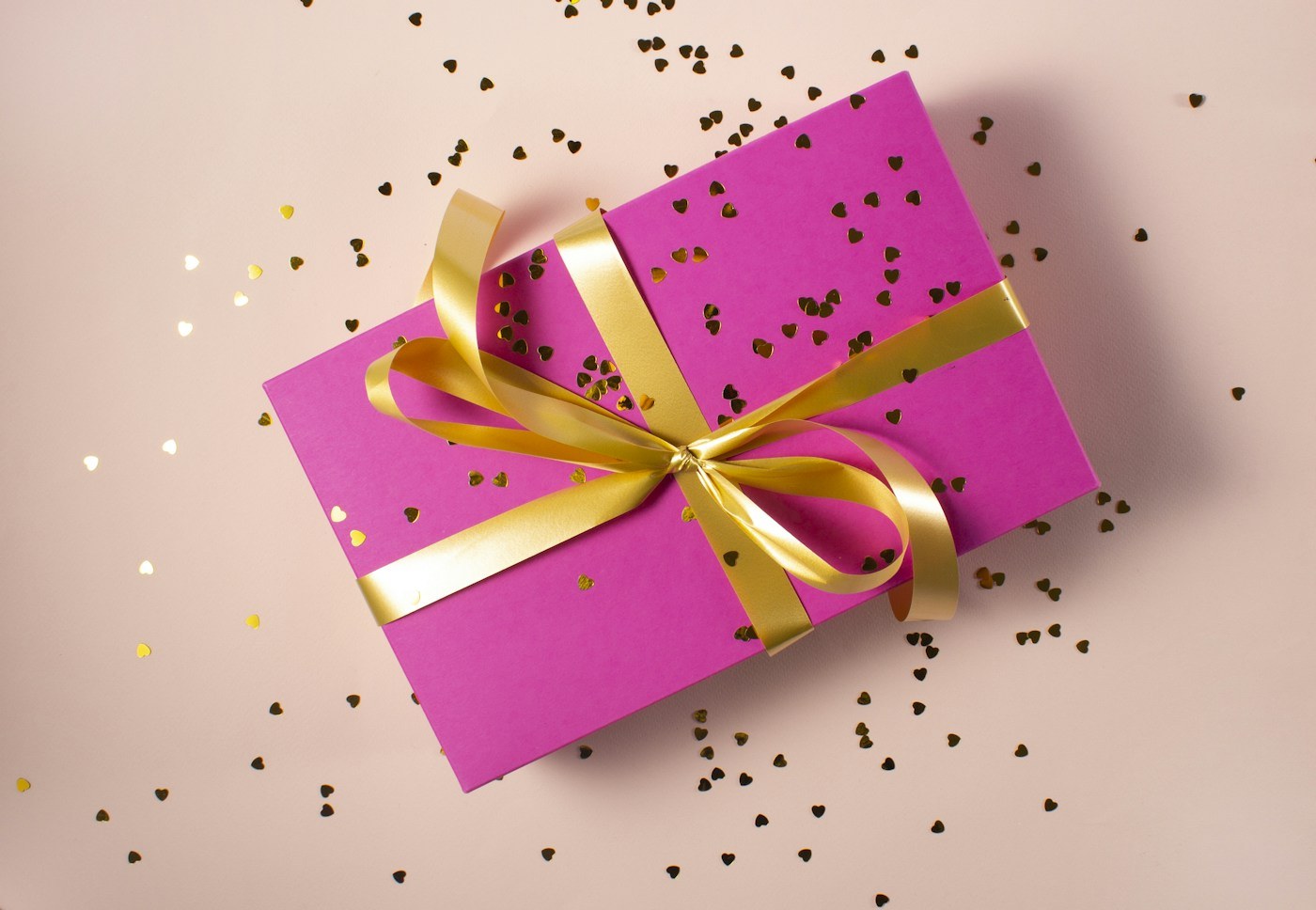 A small wrapped gift on a pink surface